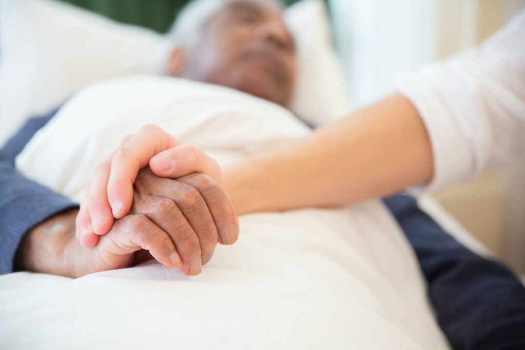 pexels-photo-7551677-7551677 A comforting gesture as a hand holds another in a hospital setting, symbolizing care and support.